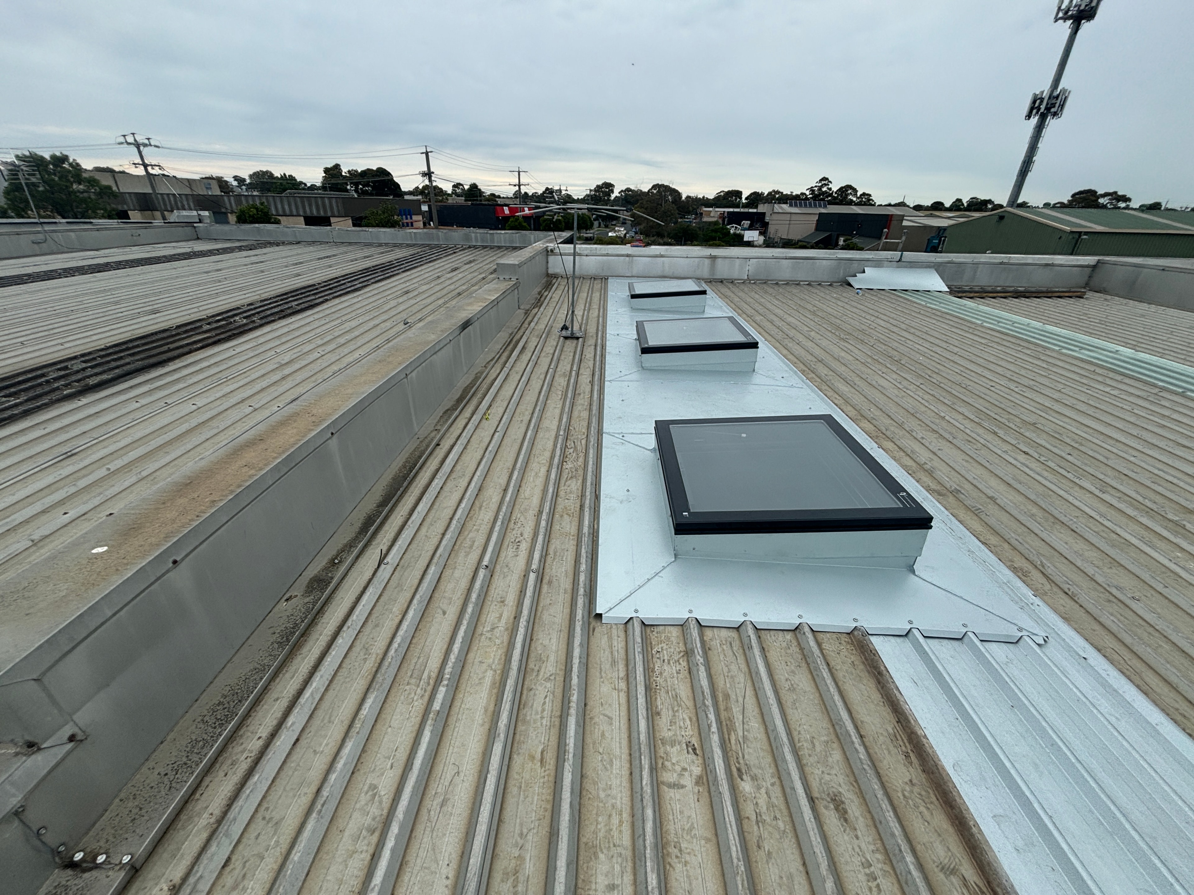 Metal roof sheeting at sunset with Melbourne suburban skyline